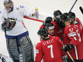 Швейцарские хоккеисты празднуют гол в ворота Гюнтера Хелла (слева). Фото AFP