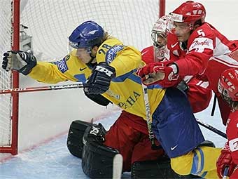 Датские хоккеисты выталкивают украинца Александра Матерюхина с пятачка. Фото AFP